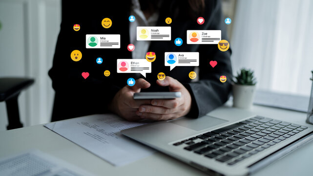 A person holds a smartphone surrounded by vibrant social media notification icons, depicting communication and engagement in a contemporary office setting. Ledger