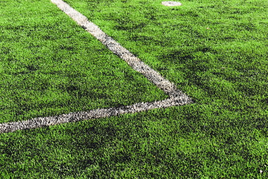 green synthetic grass field texture with white boundary line for sport background