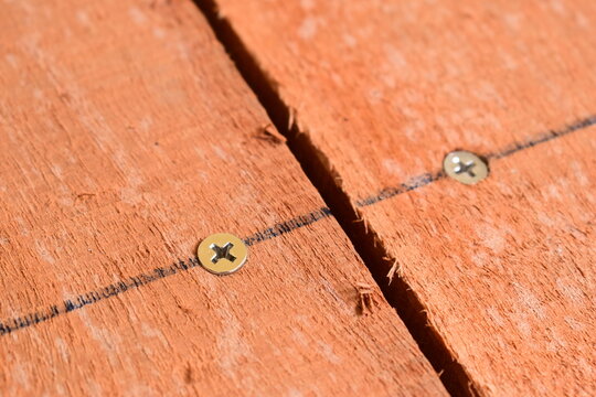 natural reddish brown wooden board texture background with visible screw
