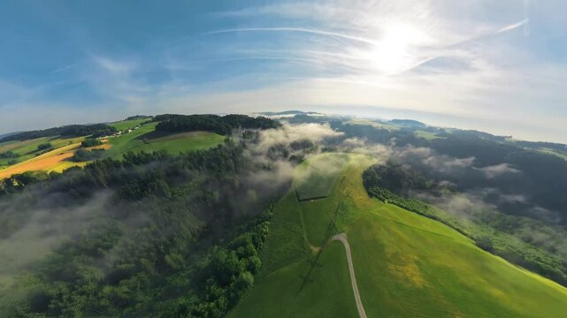 Creative drone footage transitioning from a tiny planet effect into a natural aerial view of the M&uuml;hlviertel in Upper Austria, revealing green fields, forests and rolling countryside.