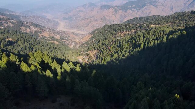 Aerial view of the lush green valley at Toli Peer, with dense forestation and mountains in the background, Rawalakot, Kashmir, Pakistan.