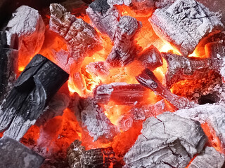 close up of burning wood charcoal with glowing red hot embers for grilling, energy, bbq and cooking, fire texture background © Muhamad