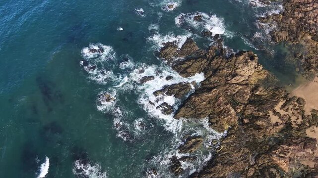 Ondas do mar a bater nas rochas da praia no Porto drone