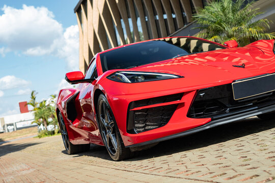 Sleek Red Chevrolet Corvette C8 Coupe Parked Outdoors in Front of Modern Architecture