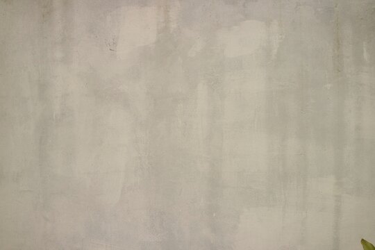An empty grey concrete wall background texture with subtle weathered stains, ideal for modern urban designs and minimalist backdrops