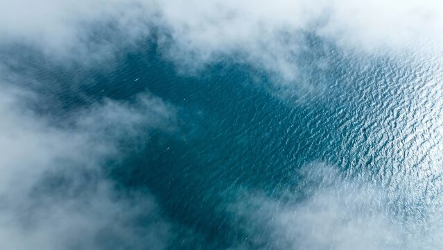 Aerial view of ocean surface partially covered by clouds