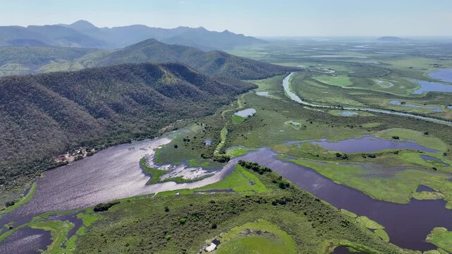 Drone aerial view of lagoons and rivers in the Southern Pantanal of Brazil, featuring the Paraguay River with the Serra do Amolar in the background, within the largest