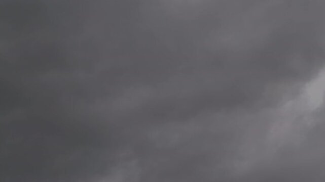 Dark gray storm clouds gathering across the sky during a gloomy overcast afternoon before heavy rain
