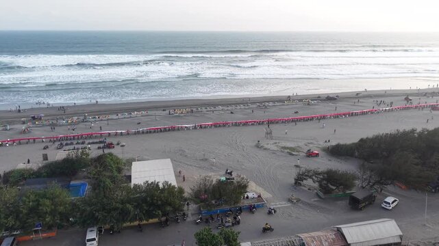 4K drone footage of Indonesia's 480-meter red and white flag unfurled at Parangtritis Beach, celebrating Indonesian Independence Day and national pride.