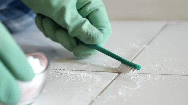 Cleaning grout in kitchen tiles with a brush
