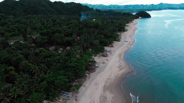 Aerial view drone fpv ascending to reveal a tropical coastline with lush greenery along the Sugar Beach. Sipalay, Philippines