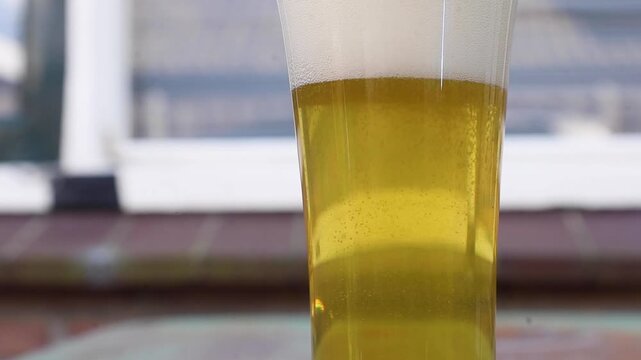 Video pouring a glass of beer, making fizzy bubbles.
