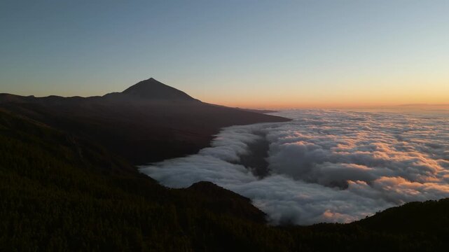 Sunrise view over Teide volcano with clouds filling the valley below in Tenerife