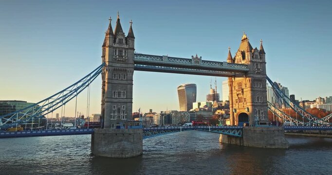 London most famous attraction - Tower Bridge standing prominently against the golden light of sunset. With the River Thames flowing beneath and the modern London cityscape with Walkie Talkie buildings