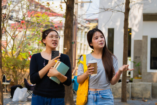 Two Asian girls using smartphone gps technology find location