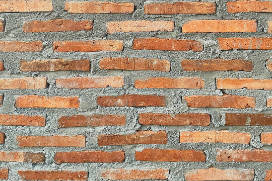 Red brick wall texture with rustic weathered surfaces, natural color variation, and light mortar joints. Classic architectural material ideal for walls, facades, backgrounds, and interiors.