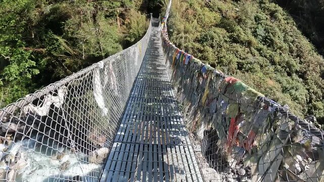 Footage while walking on the bridge for crossing Langtang Khola river a river coming from the south flows down along the Langtang trekking route, Nepal. 