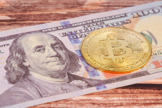 Close up view of shiny Bitcoin coins under twenty and fifty Dollars