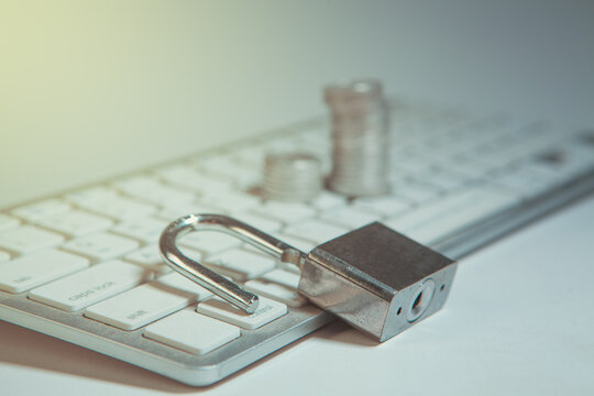 Padlock and coins on computer keyboard. Security, safety and protection concept.