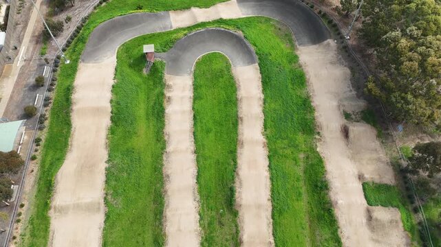 Aerial shot of formed dirt jumps, rhythm sections, roller mounds, and paved asphalt turns (berms)&nbsp;of a dedicated BMX racing track in Melbourne, Victoria, Australia. Municipal recreational facility