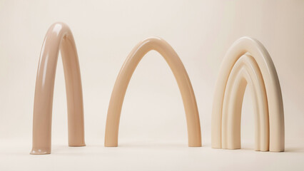 Fototapeta premium Beige arch shaped sculptures arranged on a neutral light background