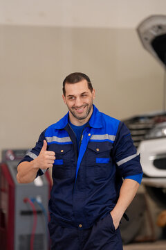 Technician mechanic garage uniform repair vehicle man smile thumb up service worker in blue coverall standing near car lift