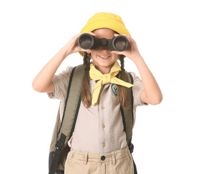 Little girl scout with backpack looking through binoculars on white background. World Scout Day