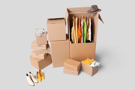 Wardrobe boxes with clothes on grey background