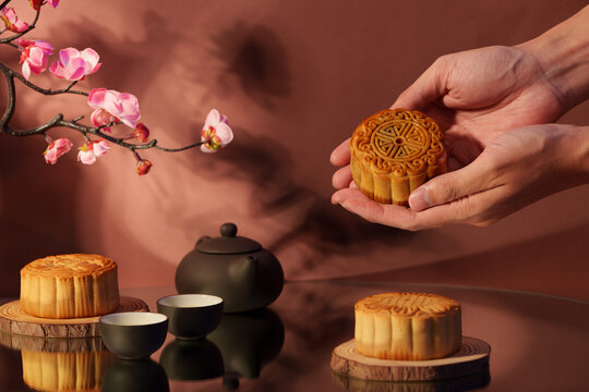 Cropped hands holding traditional mooncake for Mid-Autumn Festival celebration