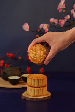 Cropped hand holding traditional mooncake for Mid-Autumn Festival celebration