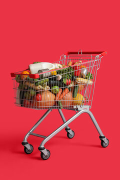 Shopping cart full of food on red background