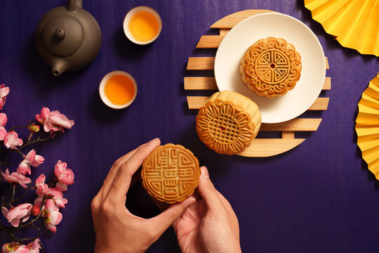 Cropped hands holding traditional mooncake for Mid-Autumn Festival celebration