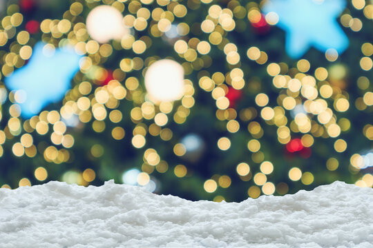 Empty white snow with blur Christmas tree with bokeh light background