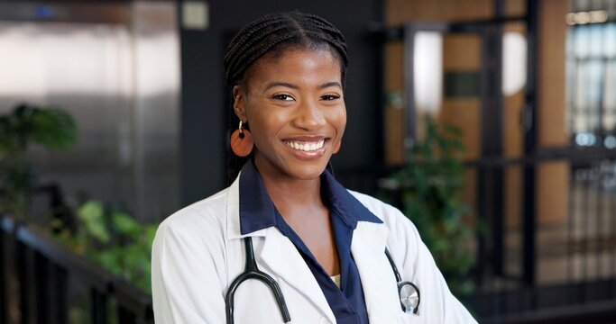 Healthcare, doctor and happy in portrait in hospital lobby, expert physician or heart specialist. African, woman or cardiologist for medical care, confidence and pride with professional in medicine