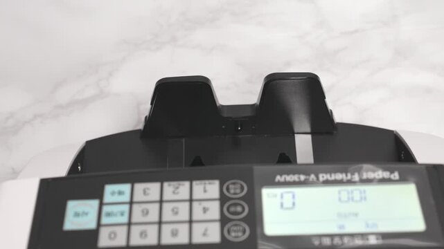 Close-up Fixed Shot of Money Counting Machine Counting 100 Crisp 50,000 Won Banknotes (Cash, Banking, Finance)
