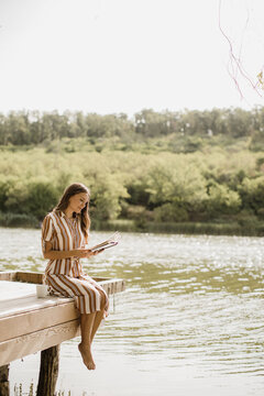 Sunlit lakeside retreat brings joy to a reader in nature's embrace