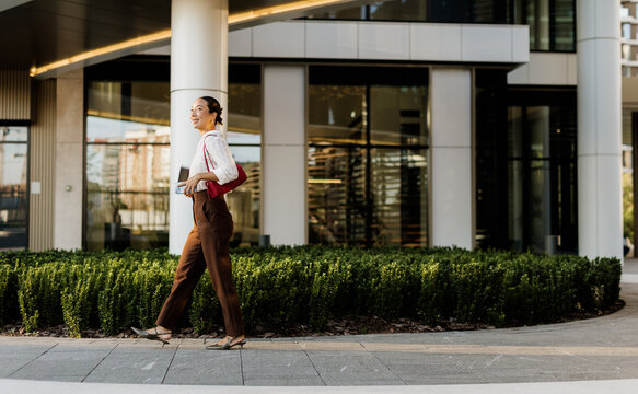 Korean woman walking gracefully through a modern urban landscape