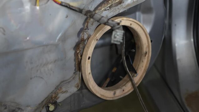 Wooden adapter ring installed on a car door for speaker.