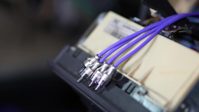 Purple RCA audio interconnect cables connected behind a car radio.