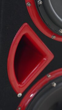 Custom car subwoofer box with red bass reflex port tube.