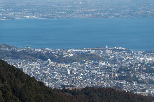 Telephoto aerial view of Beppu city dense urban buildings, residential areas, and Beppu Bay from Mt. Tsurumi.