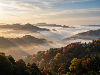 Obraz premium Autumn mountain range with morning fog and sunlight