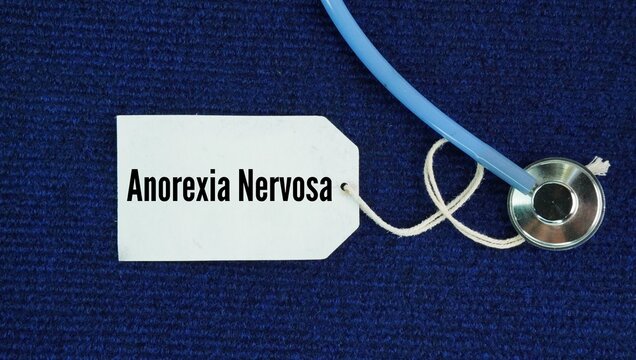 Stethoscope and paper tag with the word Anorexia nervosa. serious eating disorder where a person limits food intake due to an intense fear of gaining weight and a false view of their body size.