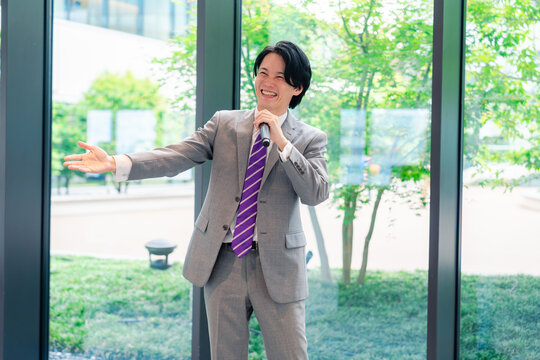 にこやかにマイクで話す男性のビジネスマン