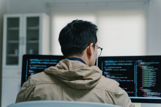 Programmer coding on dual monitors working from home