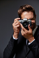 Camera, shooting and portrait of man in studio for event photoshoot pov, lens and artist. Corporate coordinator, media director and film production with person on dark background for photography © peopleimages.com