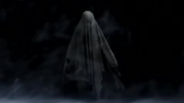 Scary sheet ghost floating in dark foggy night