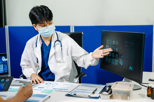 A dedicated medical team discusses patient diagnostics, reviewing brain MRIs and medical charts on digital devices