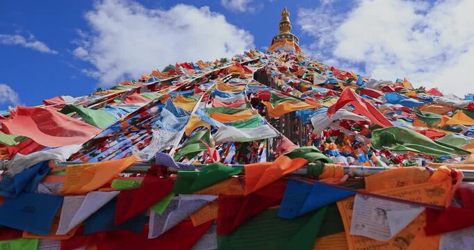 The Changqing Chunker Temple in Litang, China. Many colourful prayer flags on the mountain top beside the temple.Spirituality and meditation.	