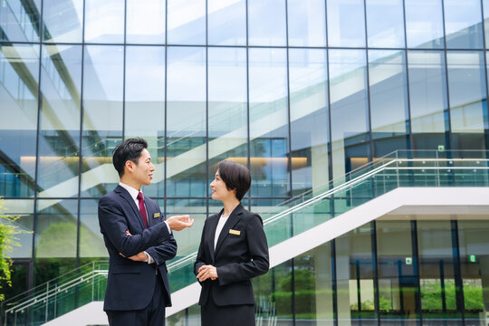 屋外で会話する男女ビジネスパーソン。相談, 笑顔, ポジティブ, 新緑, 人材, チームワーク